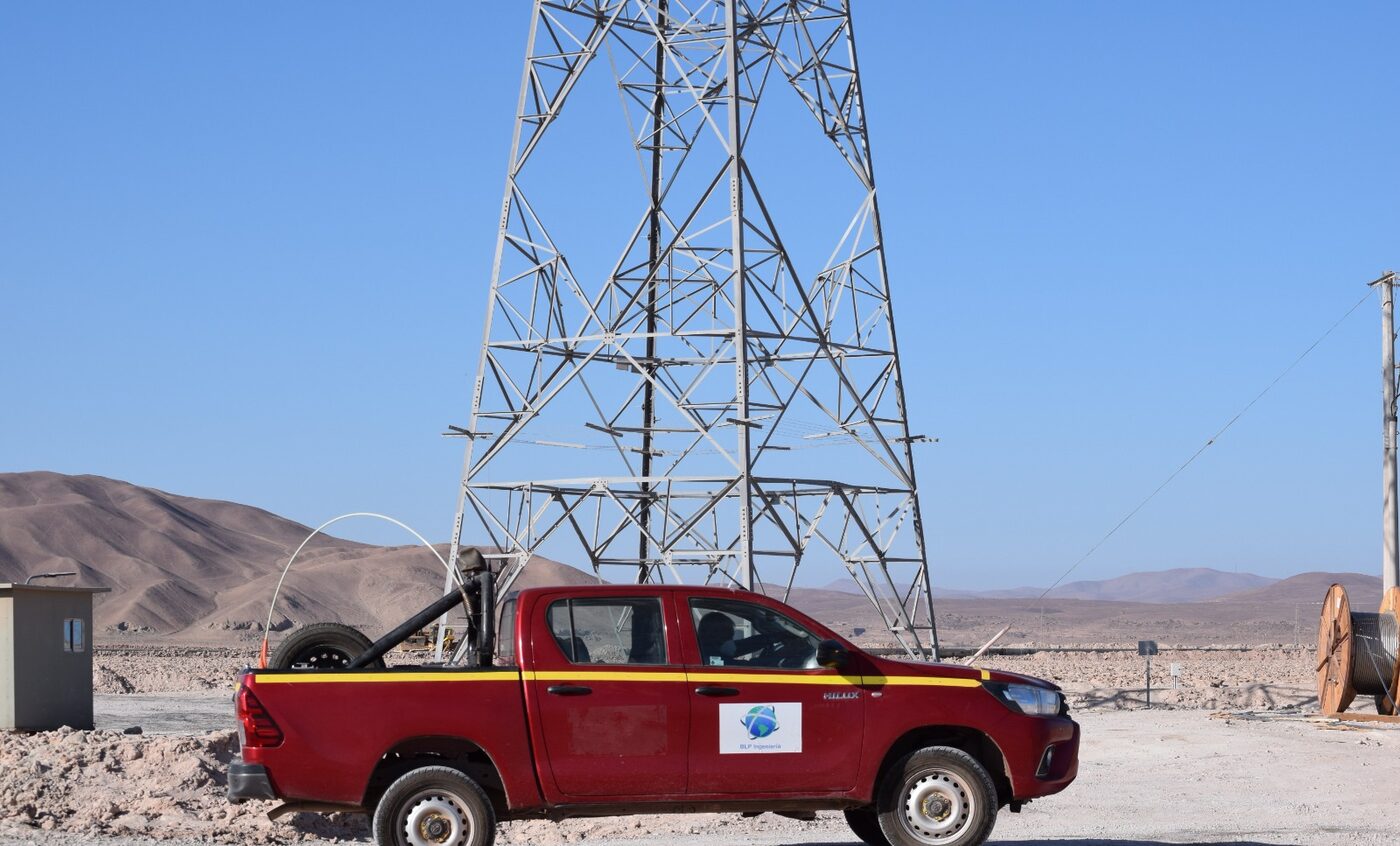 Torre de alta tensión y carrete de conductor en faena